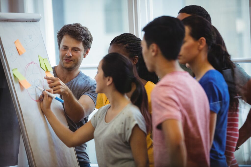 business-executive-explaining-her-colleagues-whiteboard